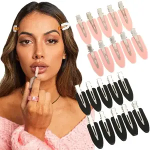 Matte Haarspangen in Rosa und Schwarz in Entenschnabel-Form, am Pony getragen und flach ausgelegt