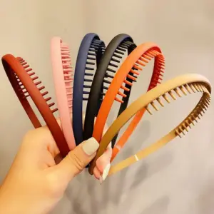 Matte Haarreifen mit kleinen Zähnen an der Innenseite in verschiedenen Farben, in der Hand gehalten