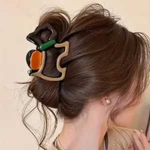 Große Haarklammer in Beige, Orange und Grün im hochgesteckten braunen Haar getragen